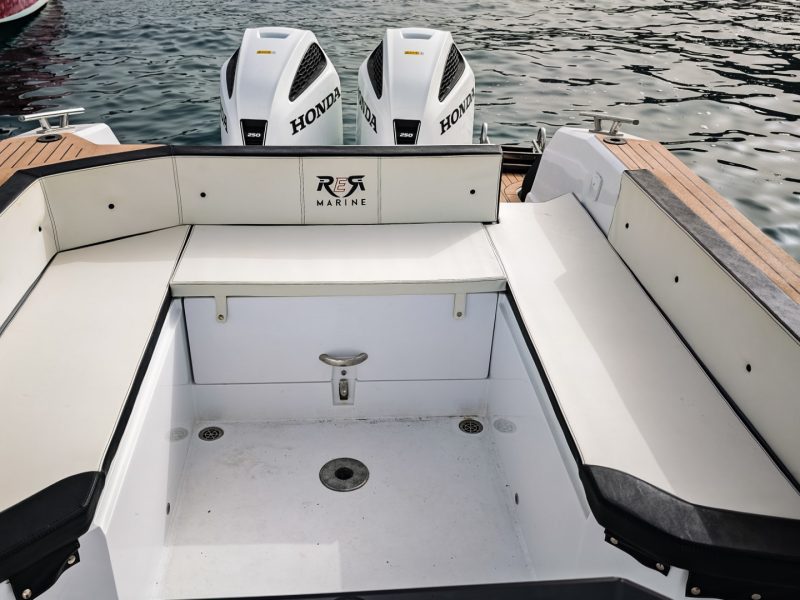 Sedute di poppa del RER Marine 999 con cuscineria chiara e due motori fuoribordo sullo sfondo.